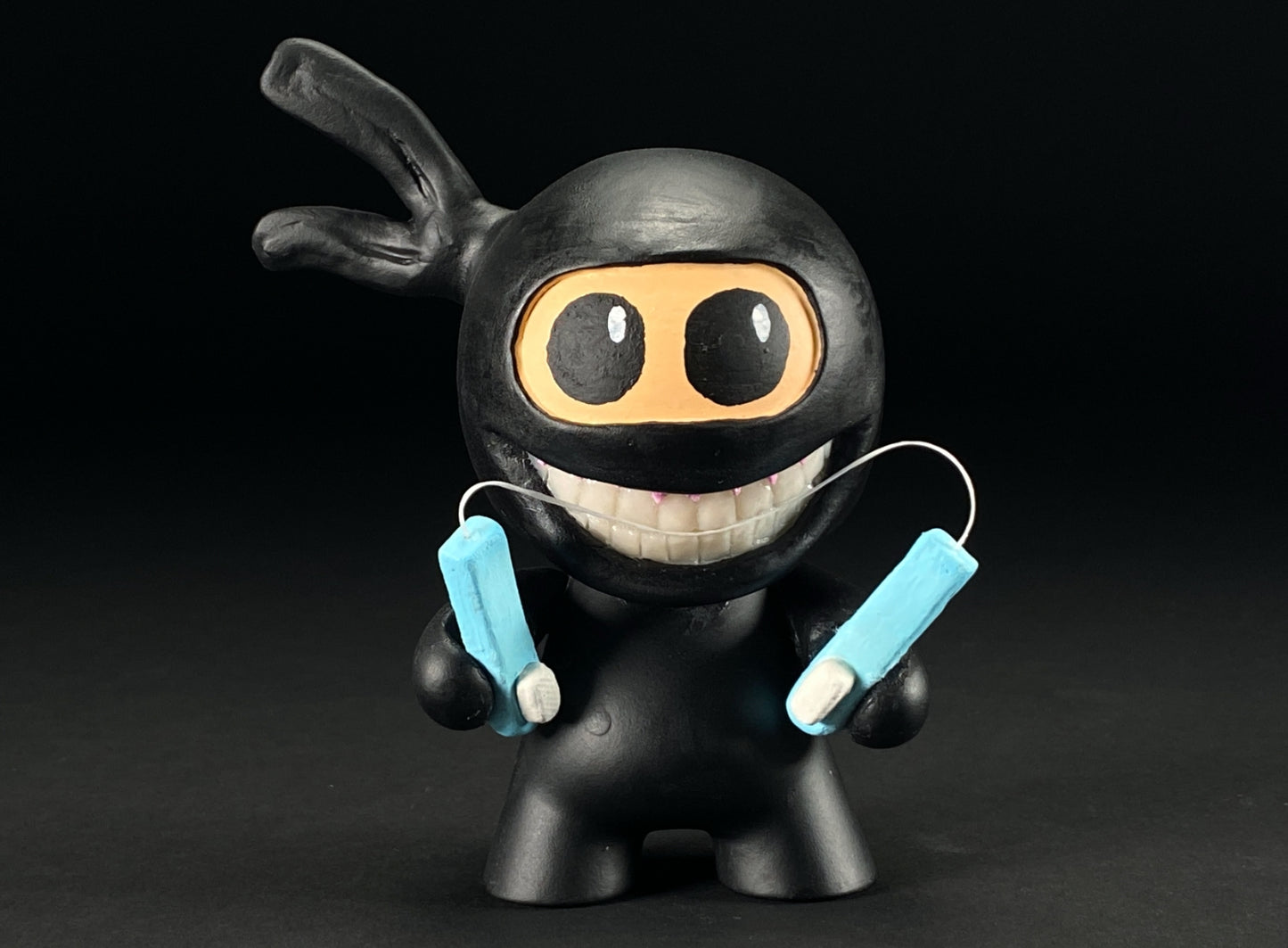 Head on shot of Ninja holding nunchucks made from toothbrushes and floss